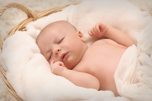 Baby sleeping is a basket covered with towels